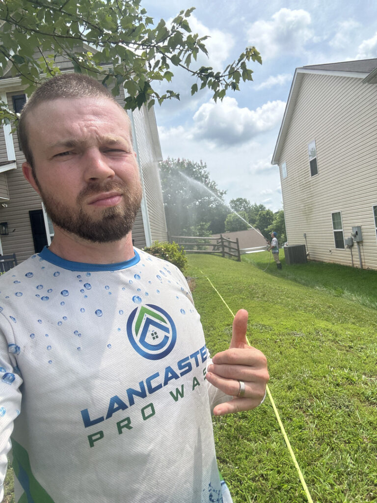 Lancaster Pro Wash | Paver Sealing lancaster pro wash technician showcasing house washing service with soft washing techniques in residential area on a sunny day